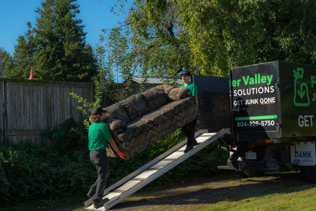 FVJS team loading up a 3 seater couch into a branded truck