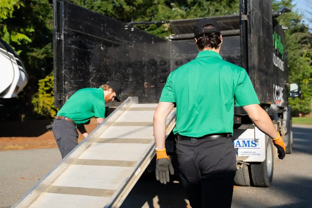 Junk removal team preparing a truck ramp for a hoarding cleanout