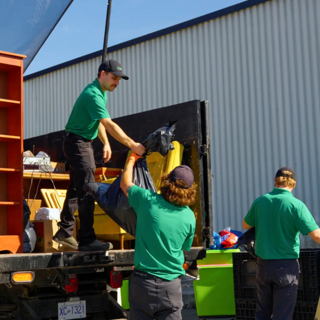 Three Fraser Valley Junk Solutions employees unloading cardboard, plastic, glass, e-waste and other recyclables at a depot in Abbotsford.